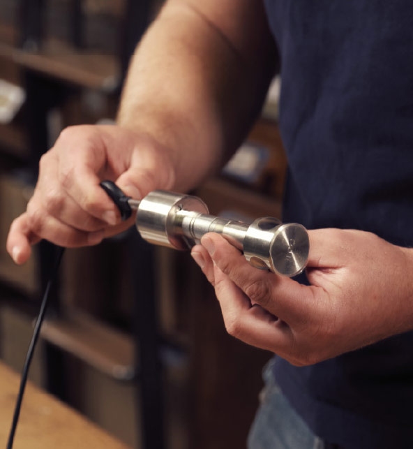 Nahaufnahme von Händen die die einen programmierten Schlüssel in einem Schloß testen